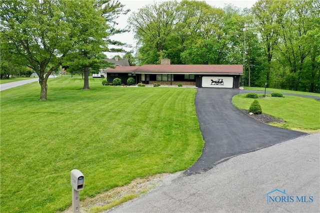 230 Orchard Ln, Upper Sandusky, OH 43351 - ranch-style house with asphalt driveway, a front lawn, a garage, and a chimney