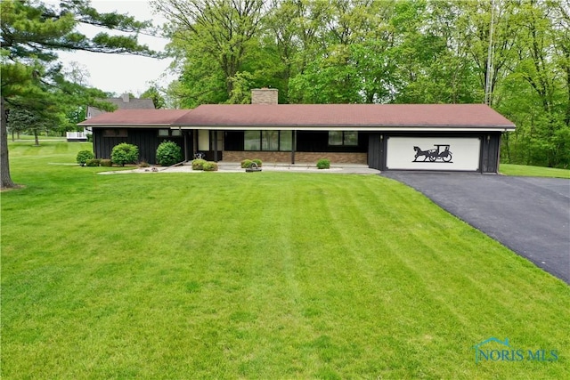 230 Orchard Ln, Upper Sandusky, OH 43351 - single story home with a garage, driveway, a front yard, board and batten siding, and a chimney