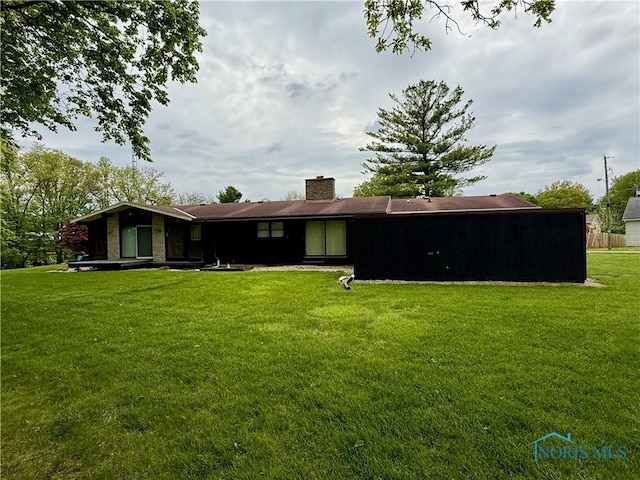 230 Orchard Ln, Upper Sandusky, OH 43351 - rear view of house featuring a yard and a chimney