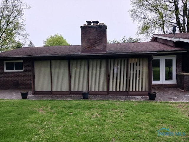 1875 State Route 101, Clyde, OH 43410 - back of property featuring a chimney, a yard, and brick siding
