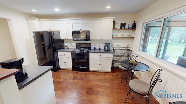 1875 State Route 101, Clyde, OH 43410 - kitchen with black appliances, dark countertops, dark wood-type flooring, white cabinets, and recessed lighting