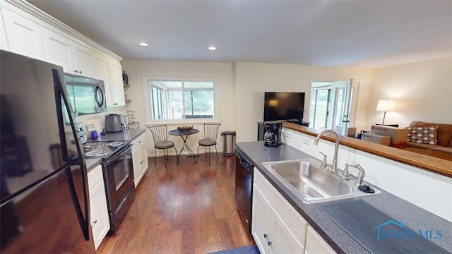 1875 State Route 101, Clyde, OH 43410 - kitchen with black appliances, a sink, dark countertops, white cabinetry, and dark wood finished floors