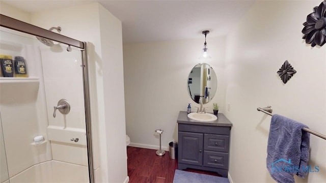 1875 State Route 101, Clyde, OH 43410 - full bath featuring a stall shower, vanity, wood finished floors, toilet, and baseboards