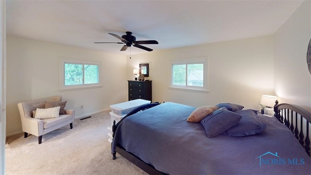 1875 State Route 101, Clyde, OH 43410 - bedroom featuring multiple windows, light carpet, a ceiling fan, and baseboards