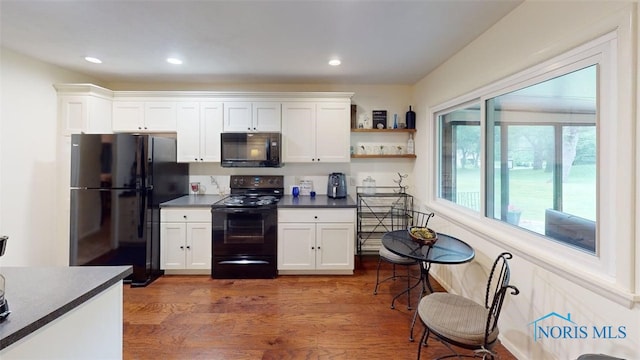 1875 State Route 101, Clyde, OH 43410 - kitchen featuring black appliances, wood finished floors, dark countertops, white cabinets, and recessed lighting