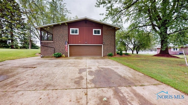1875 State Route 101, Clyde, OH 43410 - view of home's exterior featuring brick siding, a yard, an attached garage, and concrete driveway