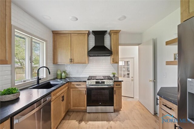 800 Pierce St, Maumee, OH 43537 - kitchen featuring stainless steel appliances, wall chimney range hood, a sink, light wood-style flooring, and decorative backsplash