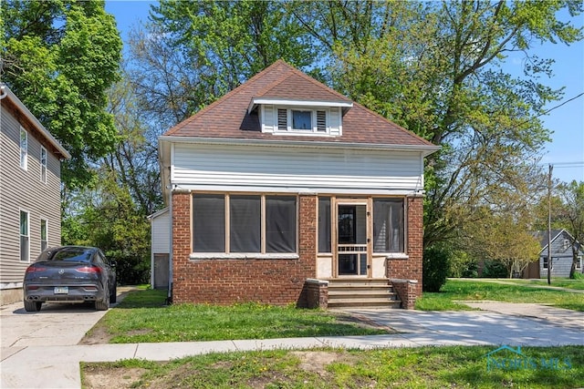 view of front of house featuring brick siding and a front lawn