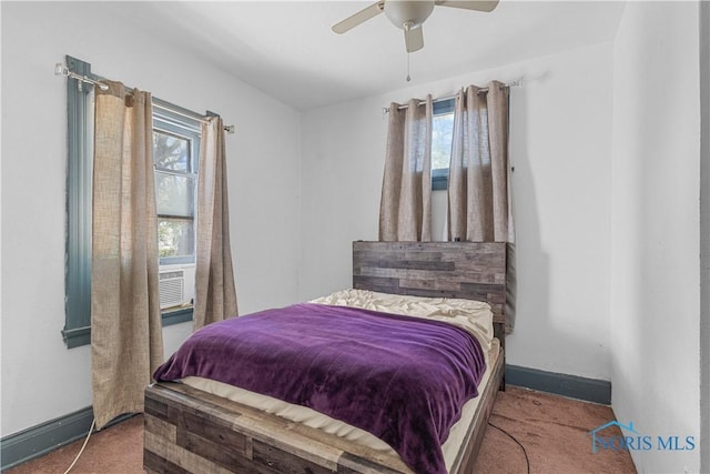 carpeted bedroom featuring multiple windows, baseboards, and ceiling fan