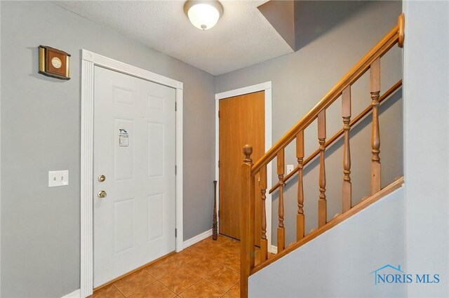 5450 Twp Rd 69, Tiffin, OH 44883 - foyer entrance with tile patterned flooring, stairway, baseboards, and a textured ceiling