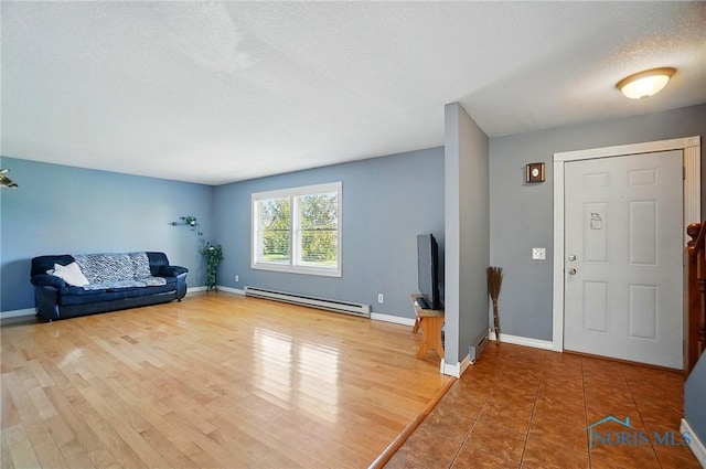 5450 Twp Rd 69, Tiffin, OH 44883 - foyer entrance featuring a baseboard radiator, a textured ceiling, baseboards, and wood finished floors