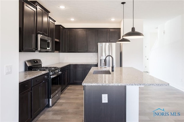 1089 Springcrest Dr, Waterville, OH 43566 - kitchen featuring appliances with stainless steel finishes, a sink, a kitchen island with sink, light stone countertops, and recessed lighting