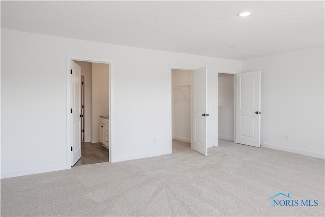 1089 Springcrest Dr, Waterville, OH 43566 - unfurnished bedroom with carpet, baseboards, a walk in closet, recessed lighting, and connected bathroom
