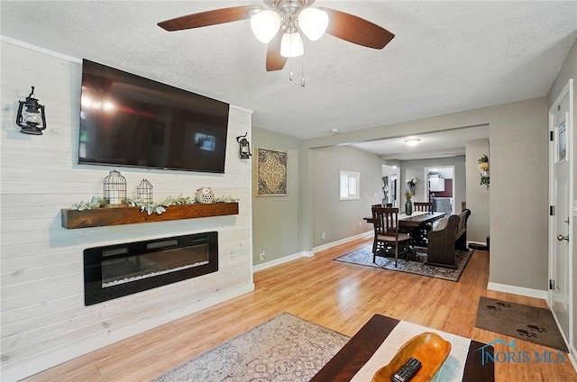 9544 Maumee Western Rd, Monclova, OH 43542 - living area with wood finished floors, baseboards, a textured ceiling, ceiling fan, and a large fireplace