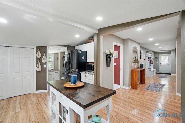 9544 Maumee Western Rd, Monclova, OH 43542 - kitchen featuring black fridge with ice dispenser, stainless steel microwave, light wood-style floors, and baseboards
