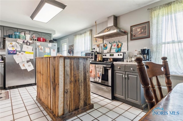 6690 County Road 219, Bellevue, OH 44811 - kitchen with stainless steel appliances, wall chimney exhaust hood, light tile patterned floors, gray cabinetry, and light countertops