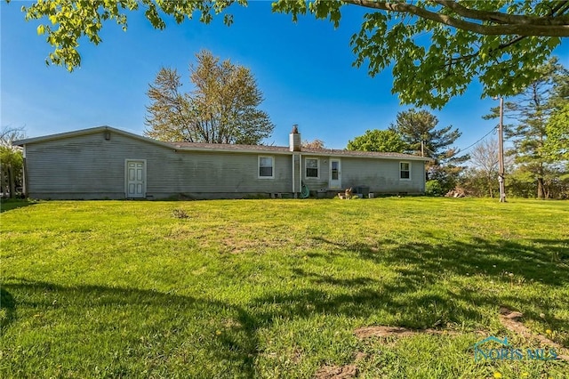 6690 County Road 219, Bellevue, OH 44811 - back of property featuring a lawn and a chimney