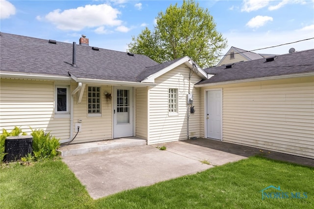 21 Pennsylvania Ave, Waterville, OH 43566 - back of house with central AC unit, roof with shingles, a chimney, and a lawn