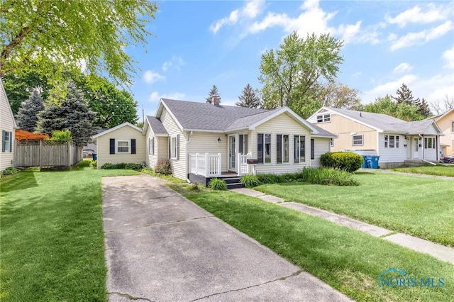 21 Pennsylvania Ave, Waterville, OH 43566 - view of front of house featuring driveway, a front yard, a shingled roof, and a chimney
