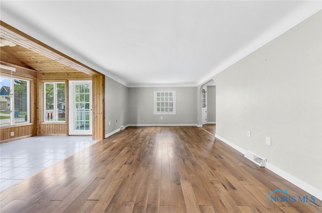 21 Pennsylvania Ave, Waterville, OH 43566 - unfurnished living room featuring plenty of natural light, arched walkways, hardwood / wood-style flooring, and beam ceiling