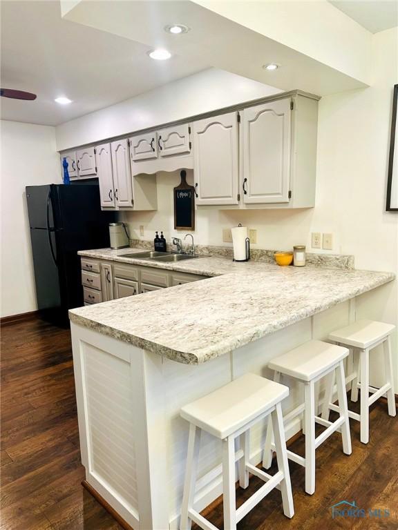 41 Salome Cir, Bluffton, OH 45817 - kitchen with a sink, a peninsula, dark wood-type flooring, light countertops, and recessed lighting