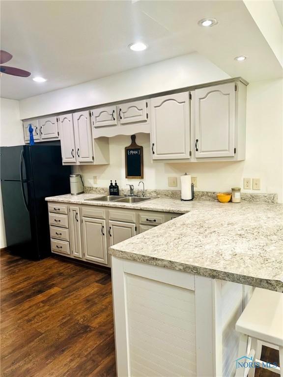 41 Salome Cir, Bluffton, OH 45817 - kitchen with a peninsula, a sink, light countertops, freestanding refrigerator, and a breakfast bar area