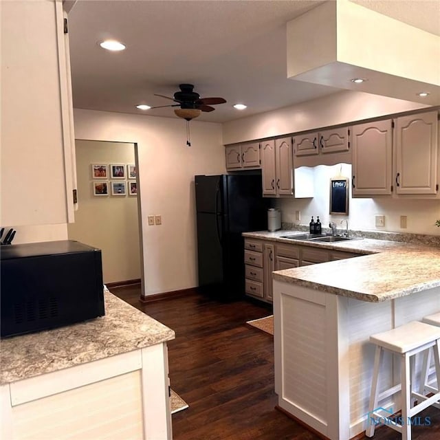 41 Salome Cir, Bluffton, OH 45817 - kitchen featuring black appliances, a ceiling fan, a peninsula, a breakfast bar area, and light countertops