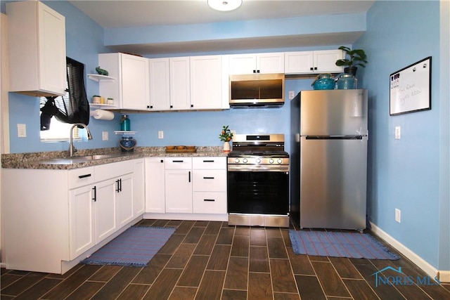 kitchen featuring stainless steel appliances, a sink, open shelves, and white cabinets