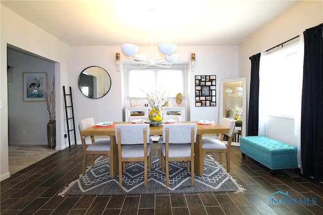 dining area with a chandelier, wood finish floors, and baseboards