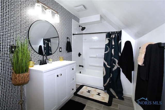 bathroom featuring shower / bath combination with curtain, vanity, and vaulted ceiling