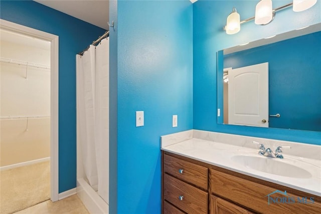 1208 Lindau St, Archbold, OH 43502 - full bath with a shower with shower curtain, vanity, a walk in closet, and tile patterned flooring