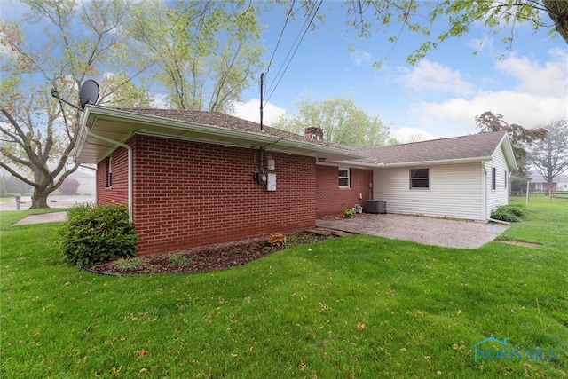 1208 Lindau St, Archbold, OH 43502 - rear view of property featuring a patio area, a yard, central AC, brick siding, and a chimney
