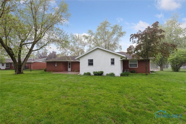 1208 Lindau St, Archbold, OH 43502 - rear view of property with a lawn and brick siding