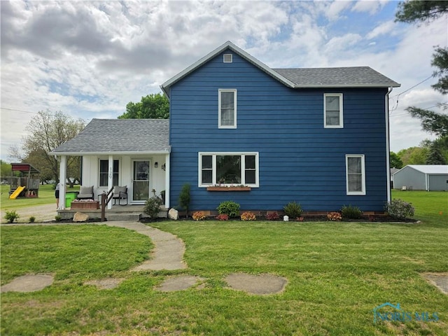129 Stahl St, Bradner, OH 43406 - traditional-style home featuring a porch, a front lawn, roof with shingles, and a playground