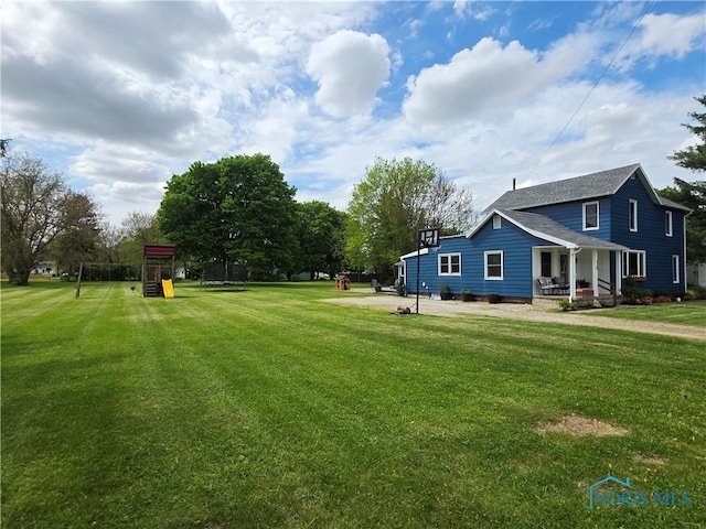 129 Stahl St, Bradner, OH 43406 - view of grassy yard featuring covered porch and a playground