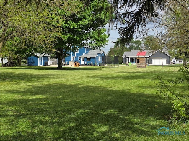 129 Stahl St, Bradner, OH 43406 - view of green lawn with a trampoline