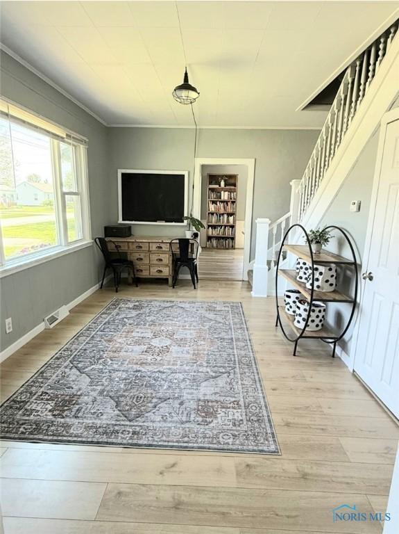 129 Stahl St, Bradner, OH 43406 - living area with wood finished floors, stairs, crown molding, and baseboards