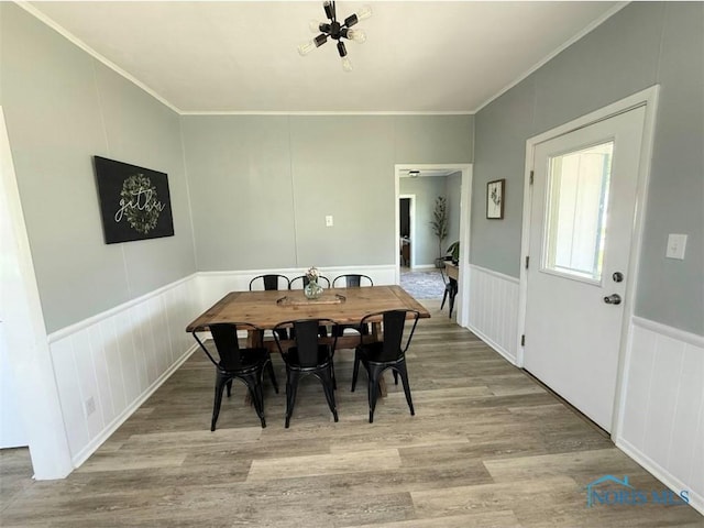 129 Stahl St, Bradner, OH 43406 - dining area featuring wood finished floors, crown molding, a decorative wall, and a wainscoted wall