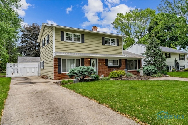 832 Maple Ln, Waterville, OH 43566 - traditional-style home with brick siding, a gate, a front lawn, concrete driveway, and a chimney