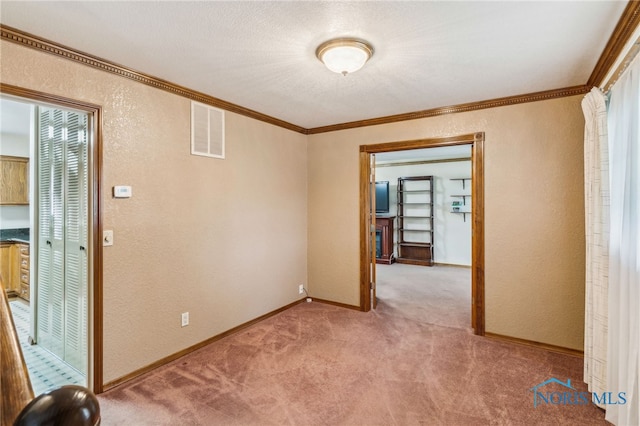 832 Maple Ln, Waterville, OH 43566 - empty room featuring a textured wall, light colored carpet, crown molding, and baseboards