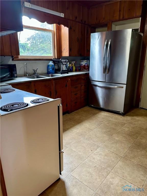 202 E Montford Ave, Ada, OH 45810 - kitchen featuring freestanding refrigerator, black microwave, range with electric stovetop, wall chimney exhaust hood, and light countertops