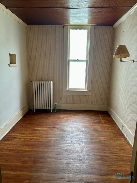 202 E Montford Ave, Ada, OH 45810 - empty room featuring radiator, wood finished floors, and ornamental molding