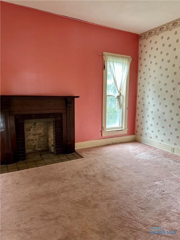 202 E Montford Ave, Ada, OH 45810 - unfurnished living room featuring a fireplace with flush hearth, carpet, and baseboards