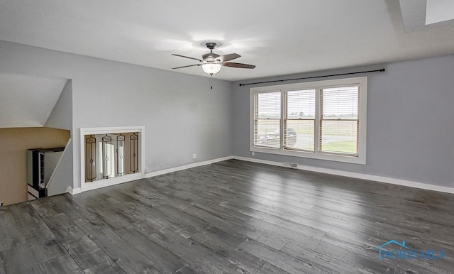 17315 County Road R, Napoleon, OH 43545 - unfurnished living room featuring a ceiling fan, dark wood-type flooring, and baseboards