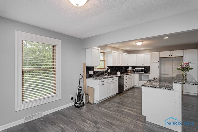 17315 County Road R, Napoleon, OH 43545 - kitchen featuring appliances with stainless steel finishes, dark stone countertops, backsplash, baseboards, and a textured ceiling