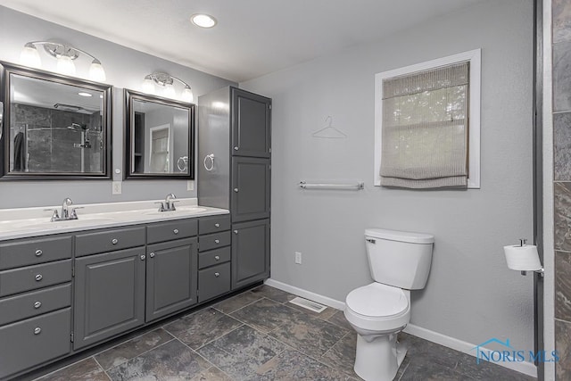 17315 County Road R, Napoleon, OH 43545 - bathroom featuring baseboards, toilet, double vanity, and stone finish flooring