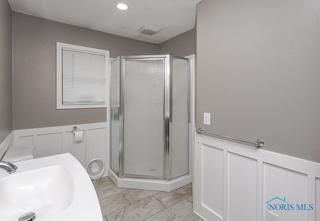 17315 County Road R, Napoleon, OH 43545 - full bathroom with a sink, a decorative wall, a shower stall, and wainscoting