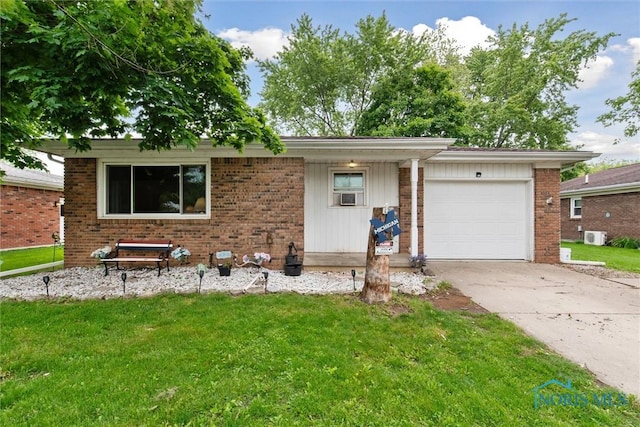 417 Indian Rd, Wauseon, OH 43567 - view of front facade with an attached garage, driveway, brick siding, a front yard, and cooling unit