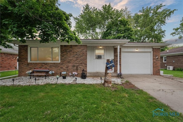 417 Indian Rd, Wauseon, OH 43567 - view of front of home with brick siding, concrete driveway, a garage, and a front yard