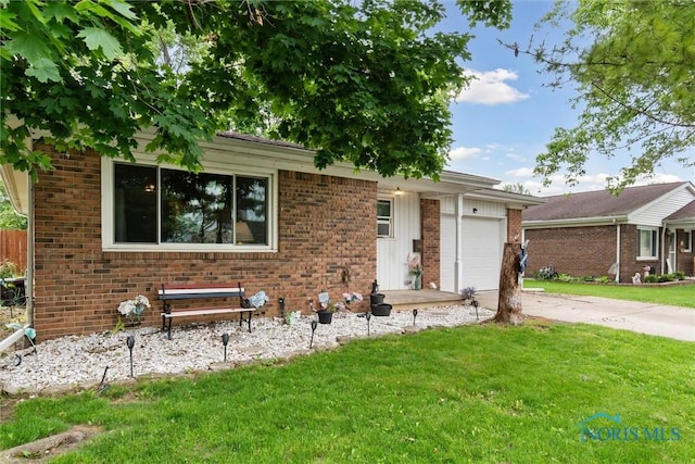 417 Indian Rd, Wauseon, OH 43567 - view of front facade featuring an attached garage, a front yard, brick siding, and concrete driveway